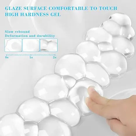 A hand gently touches a clear, high-hardness gel surface used as an ergonomic cloud wrist rest for keyboard and mouse.