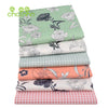 Gestapelte Twill-Baumwollstoffe mit floralen und botanischen Mustern in verschiedenen Grüntönen, Rosa und Weiß.