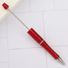 A red DIY beadable pen with a silver tip is shown resting on a white surface.