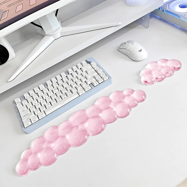 Reposamuñecas ergonómico de nube rosa para teclado y ratón, junto a un teclado y ratón de computadora.