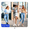 Three young women posing for a group photo using an extendable selfie stick tripod.