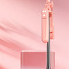 A pink 360 degree rotation selfie stick is shown resting on a glass box with soft lighting.