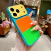 A hand holds a Dopamine Multicolor Block Acrylic phone case in bright orange, green, and blue colors.