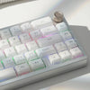A close-up view of a silver mechanical keyboard featuring custom printed jelly keycaps and various function keys.