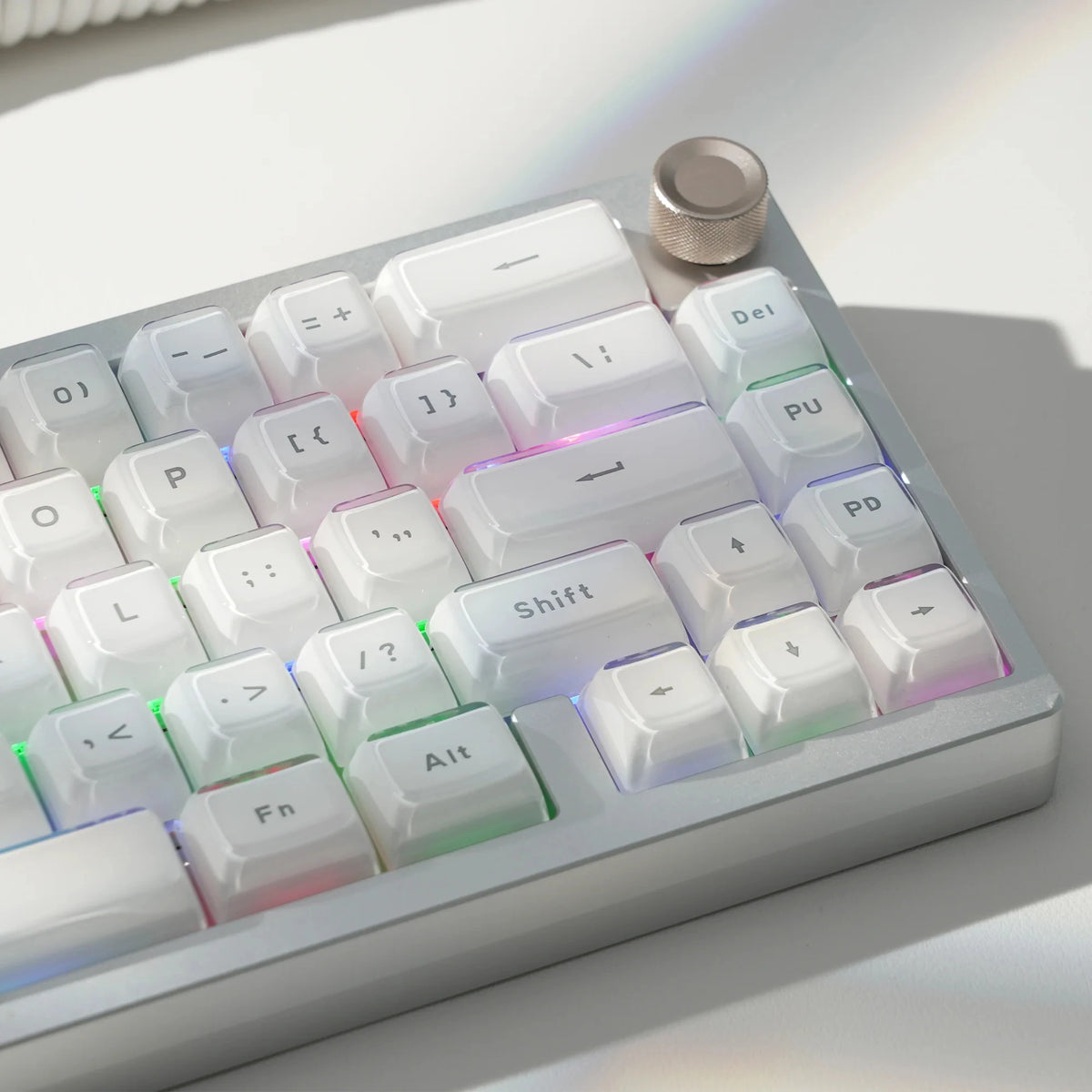 A close-up view of a silver mechanical keyboard featuring custom printed jelly keycaps and various function keys.