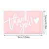 Pink thank you card with handwritten white text saying thank you and a heart symbol