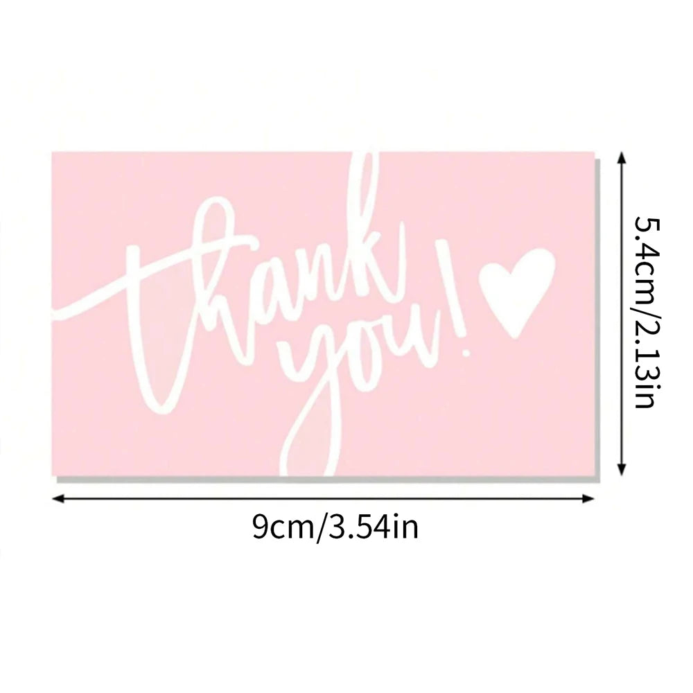 Pink thank you card with handwritten white text saying thank you and a heart symbol