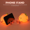 An adorable peach-shaped rechargeable night light used as a phone stand for better viewing.