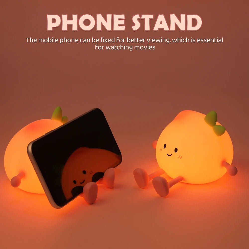 An adorable peach-shaped rechargeable night light used as a phone stand for better viewing.