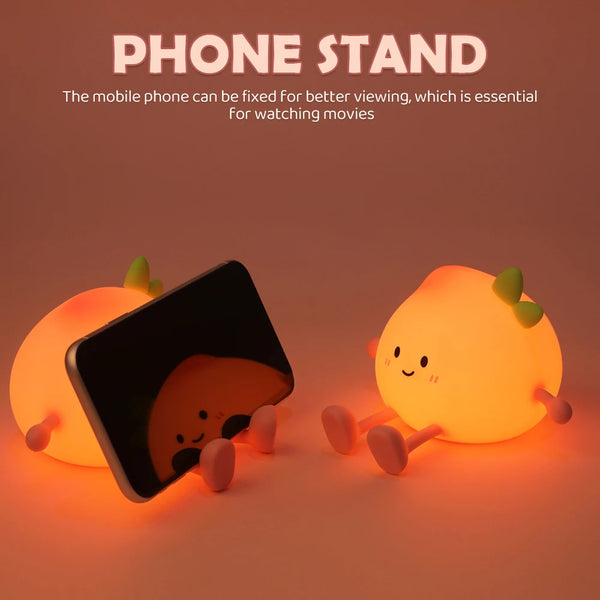 An adorable peach-shaped rechargeable night light used as a phone stand for better viewing.