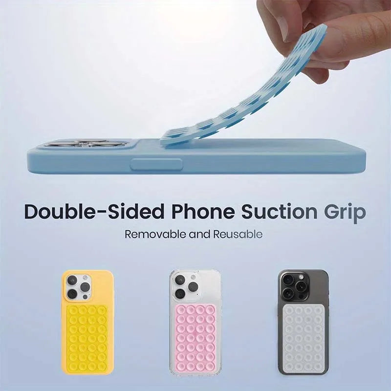 A hand is holding a light blue double-sided silicone suction cup grip designed to mount a phone.