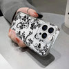 A clear phone case with a black floral pattern featuring butterflies is held by a hand.