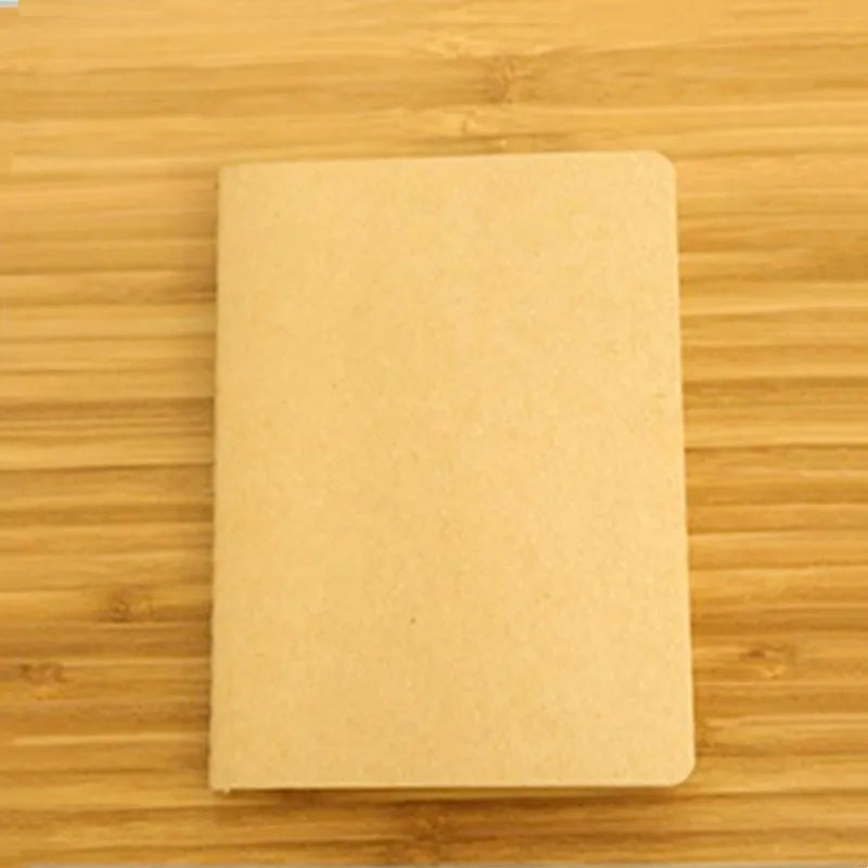 A blank A6 sketchbook lying on a wooden surface.