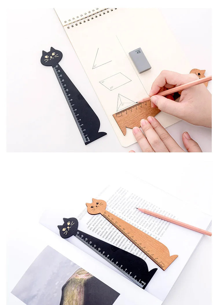 A hand uses a wooden drawing ruler shaped like a cat to measure lines on a sheet of paper.