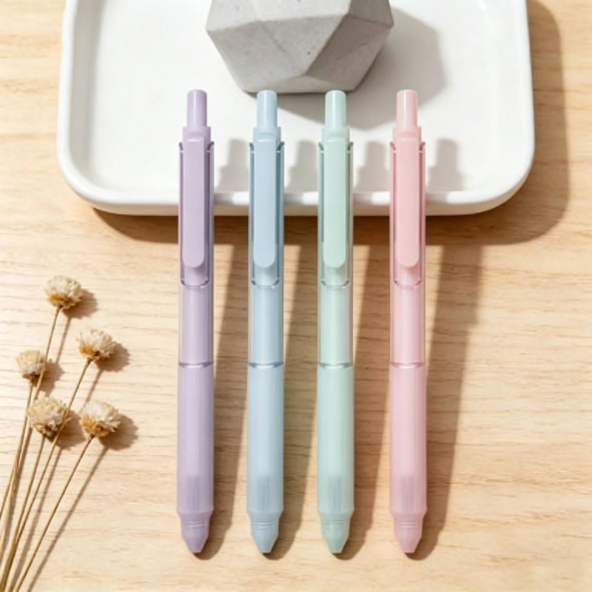 A pack of four pastel gradient gel pens in lavender, blue, mint green, and pink are displayed on a white tray.