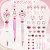 A set of six pink and clear acrylic beaded pens with decorative ribbons and gradient colors.