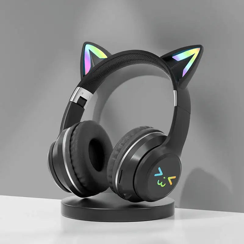 Black Bluetooth headphones with cat ear design and RGB lighting resting on a stand.