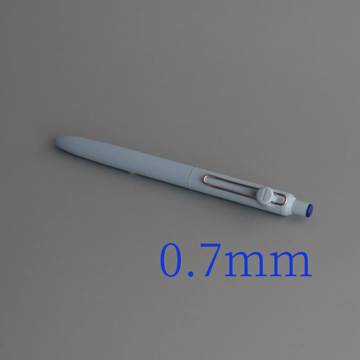 A close-up view of a light gray precision gel pen with a 0.7mm tip.