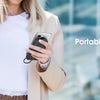A woman holds a portable charger device while wearing a light jacket, demonstrating portable charging.
