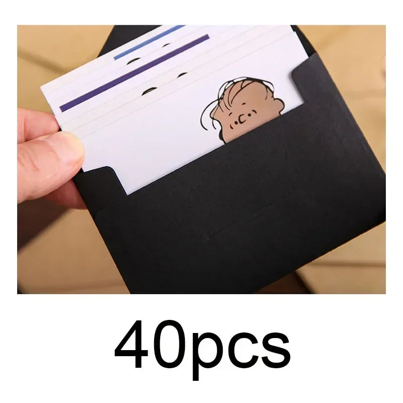 Una mano sostiene un sobre negro con una pila de tarjetas de invitación de boda blancas con un dibujo simple en una.