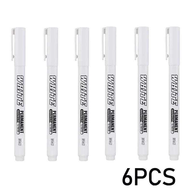 Six pieces of white permanent metal paint markers displayed in a row.