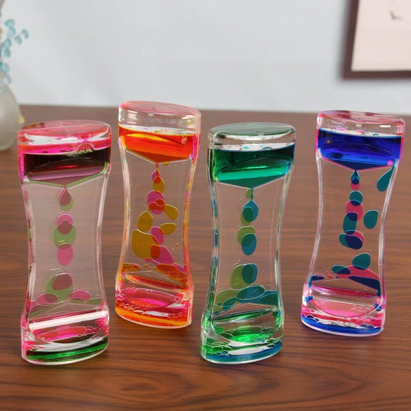 Collection d'horloges à sable en verre colorées remplies de liquide, présentées sur une surface en bois.