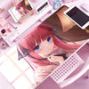 A close-up of a pink-haired anime girl resting her hand on a purple rubber mouse pad and desk mat surrounded by electronic de