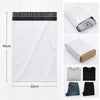 A white self-adhesive courier mailer bag with a black top and a black t-shirt shown next to various clothing items.