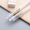 A set of clear plastic mechanical pencils with yellow and black markings resting on a light brown surface.