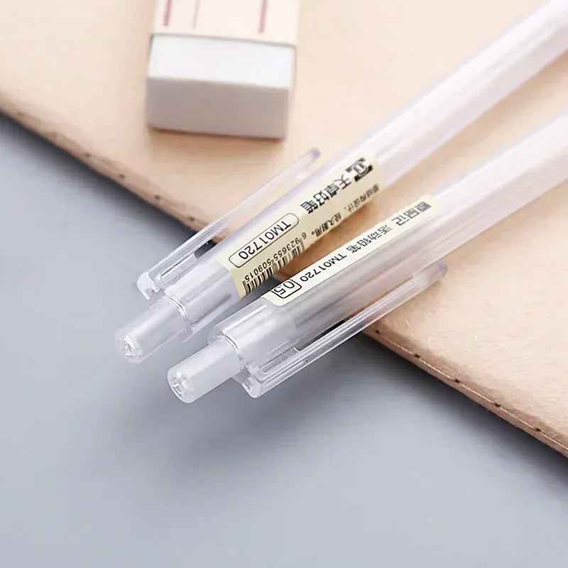 A set of clear plastic mechanical pencils with yellow and black markings resting on a light brown surface.