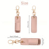 A light pink leather pen holder keychain with a gold-tone clasp and a rectangular tag.