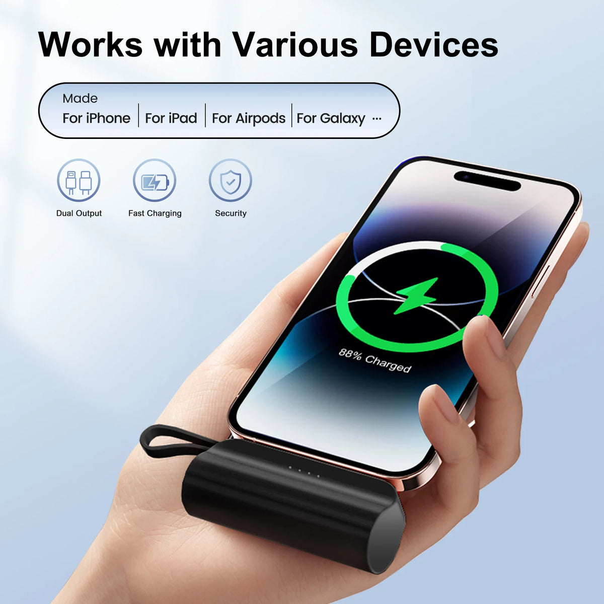 A hand holds a black compact power bank with a USB-C port, demonstrating its use for charging an iPhone.