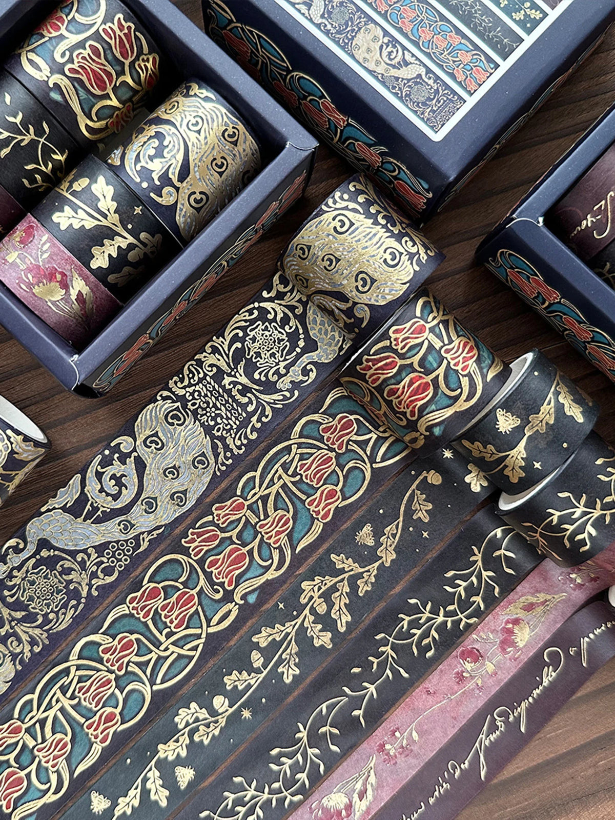 A set of metallic gold washi tape rolls in various colors and patterns displayed on a wooden surface.