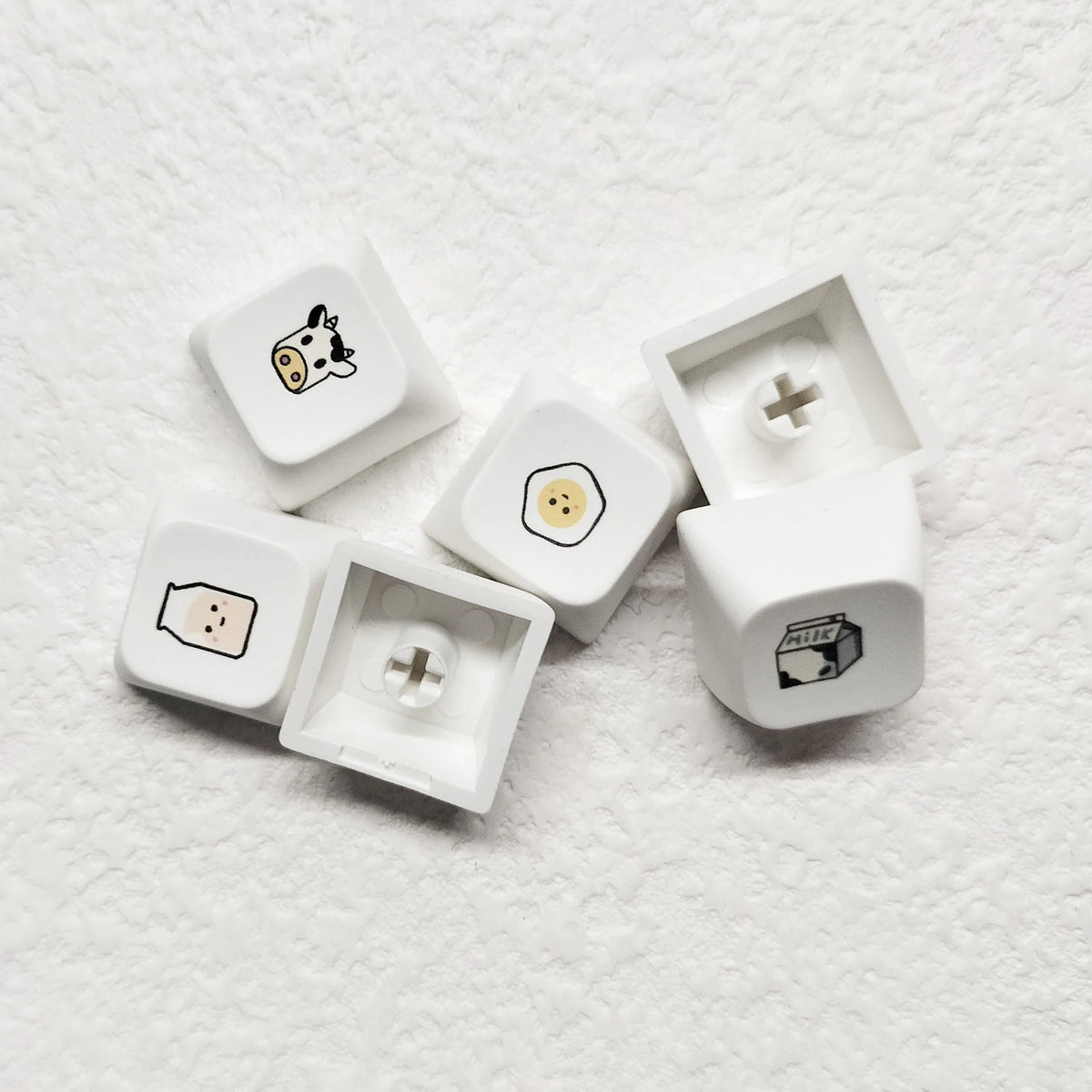 Eine Sammlung weißer PBT-Tastenhuber mit verschiedenen mehrsprachigen Symbolen und Icons für eine mechanische Tastatur