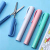 Ein Set aus vier farbigen, faltbaren, aus Edelstahl gefertigten Taschenscheren mit Stiftfunktion, präsentiert vor blauem Hint
