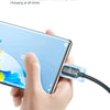 A hand is connecting a 120W USB-C to USB-C fast charging cable with a cooling module to a smartphone.