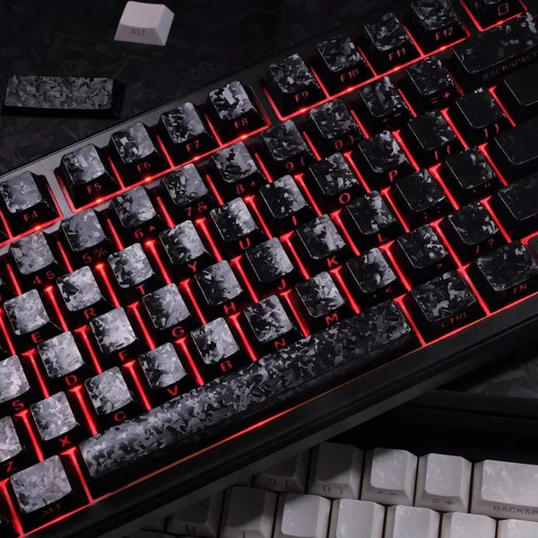 Close-up view of a black mechanical keyboard with carbon fiber keycaps and red backlit keys.