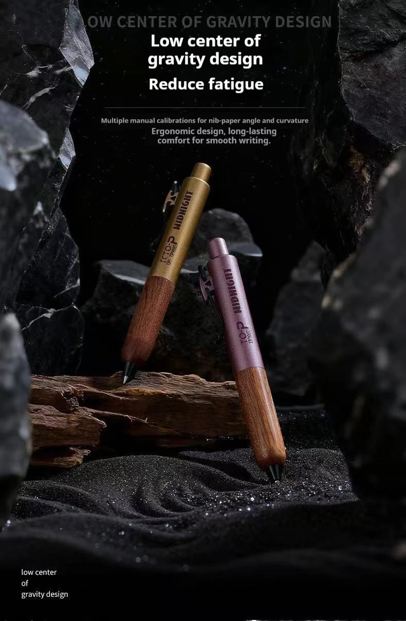 Pluma de madera marrón con clip dorado sobre una superficie oscura texturizada rodeada de rocas negras.
