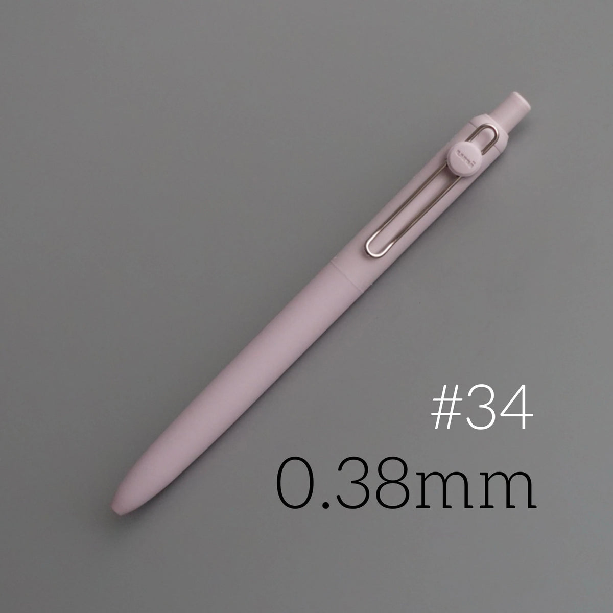 A pink precision gel pen with a silver clip and a clear barrel is shown diagonally on a gray background.