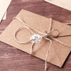 A kraft paper envelope tied with twine, resting on a dark wooden surface.