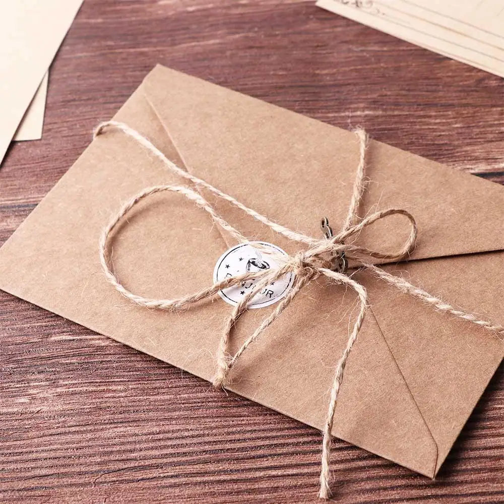 A kraft paper envelope tied with twine, resting on a dark wooden surface.