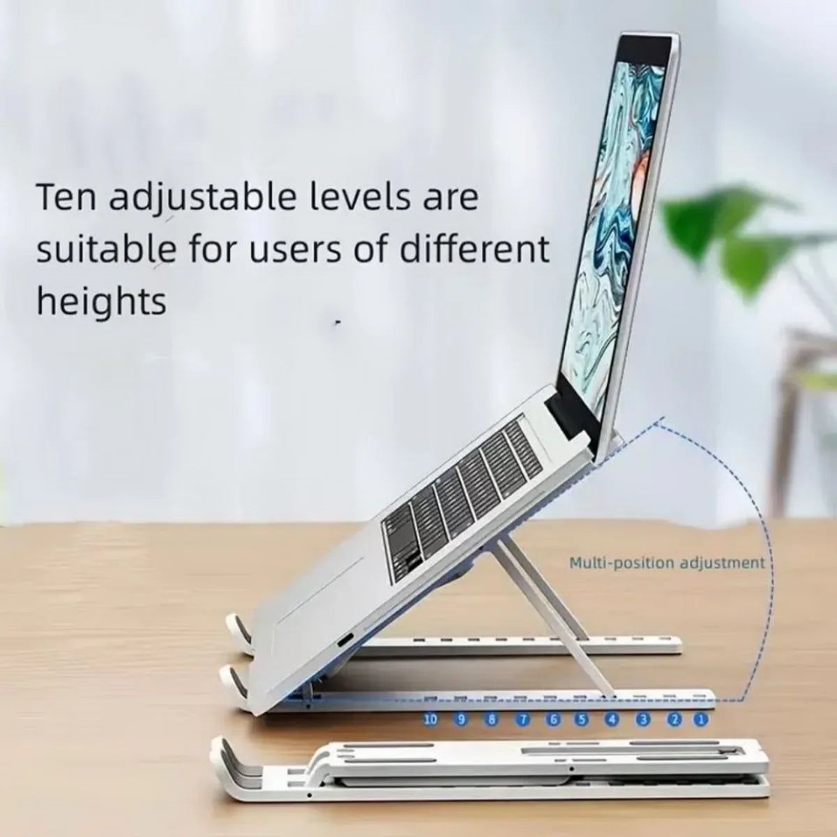 A silver portable folding laptop stand with ten adjustable levels shown next to a laptop.