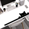 A black silhouette of a cute cat is printed on a white mouse pad placed on a desk.