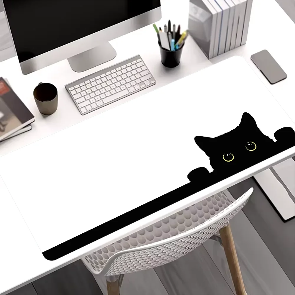 A black silhouette of a cute cat is printed on a white mouse pad placed on a desk.