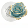 A close-up of a floral design featuring a blue-green rose with gold accents on a white background.