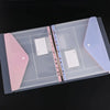 A clear plastic binder organizer tray with pink and purple pockets for holding ring binders.