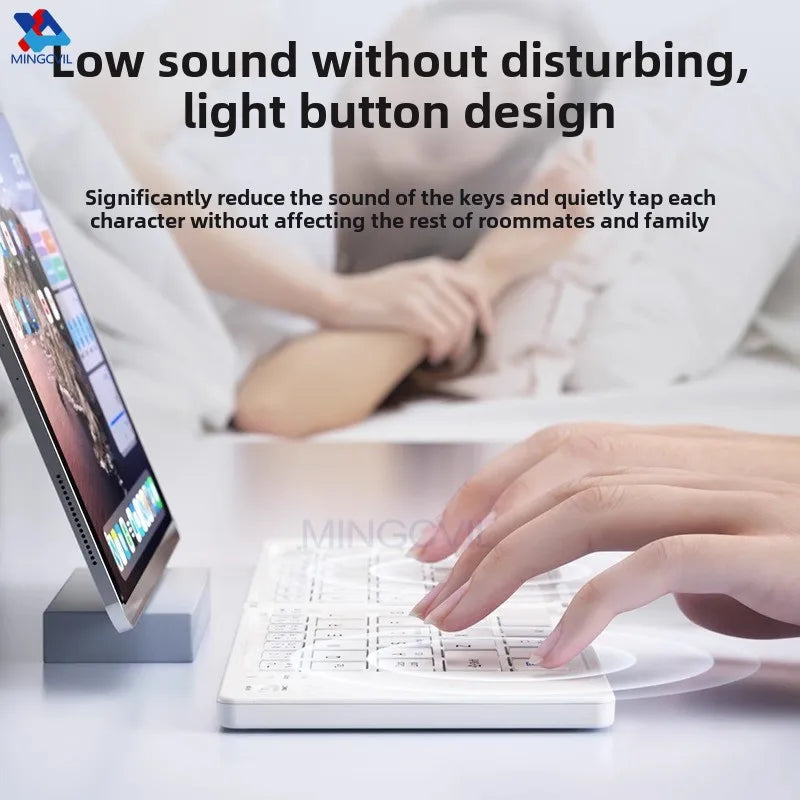 A hand is typing on a white foldable Bluetooth keyboard with a light button design.