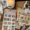 A flat lay of retro 3D relief book gallery stickers and related crafting materials on a wooden surface.