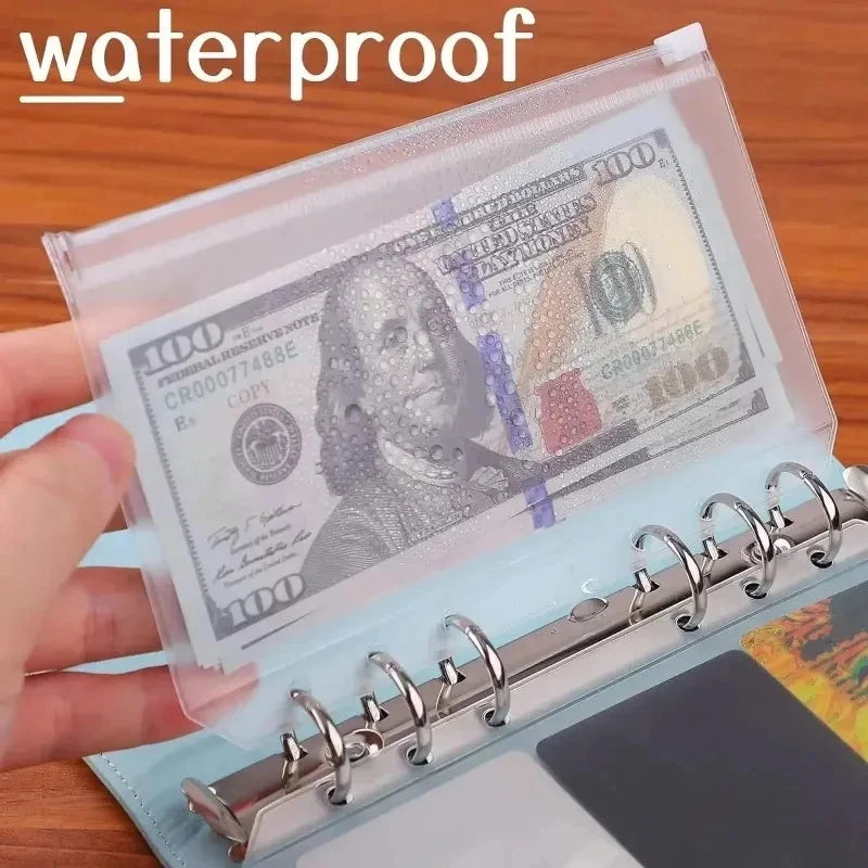 A clear waterproof envelope containing a $100 bill and a metal zipper for budget envelopes.