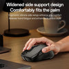A hand holds a black ergonomic mouse on a wooden desk, demonstrating its side support design.